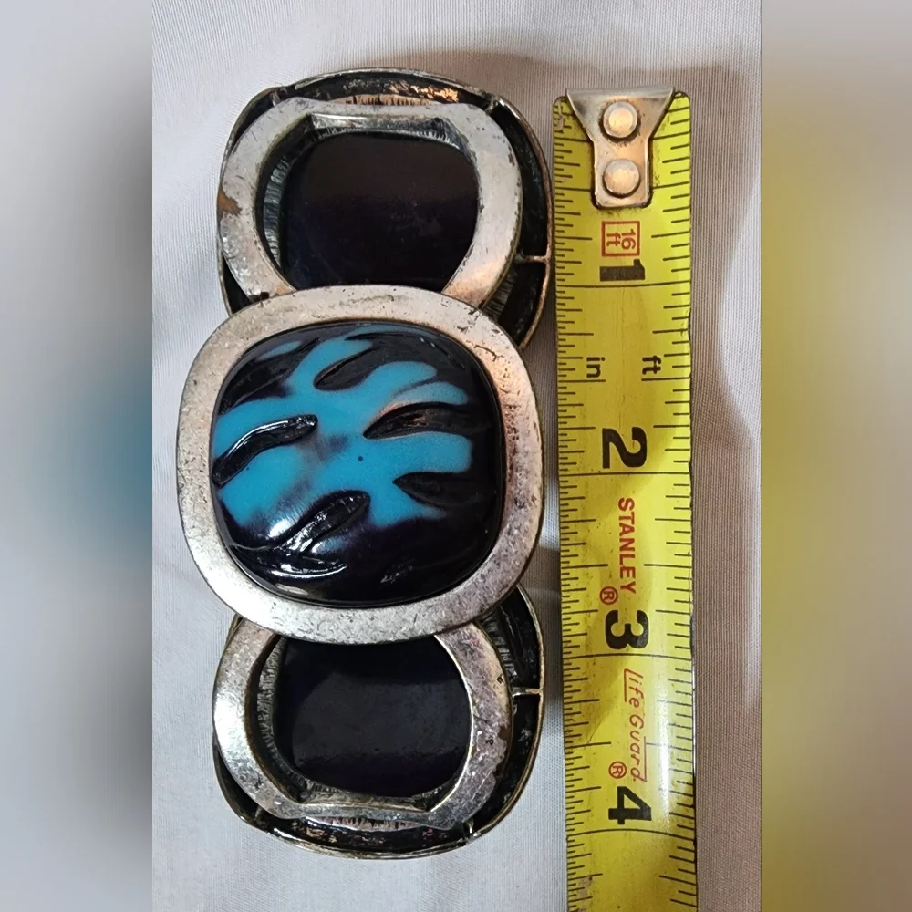 Cuff bracelet with a large, square, blue and black stone set in a Silver Tone